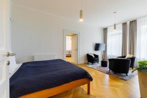 a bedroom with a bed and two chairs in it at Óváros Residence in Veszprém