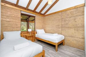 ダンズボローにあるGrasstree Cottage - Woodstone Estateのベッドルーム1室(ベッド2台、窓付)
