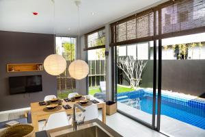 a kitchen with a dining table and a swimming pool at Villoft Zen Living Resort in Thalang