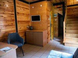 a room with wooden walls and a tv and a chair at Półwysep Natura Tour in Jastarnia