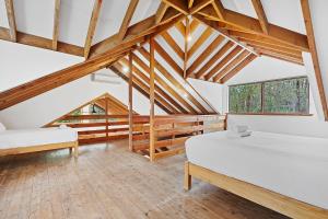 a attic bedroom with two beds and wooden beams at Kookaburra Cottage at Woodstone Estate in Dunsborough