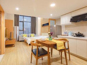 a kitchen and living room with a table and a couch at July Apartment in Hangzhou