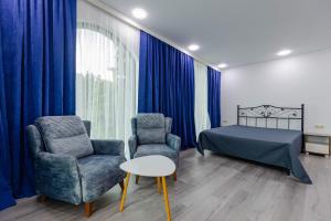 a bedroom with a bed and two chairs and a table at House at the Sea in Batumi