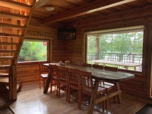 una sala da pranzo con tavolo e sedie in una cabina di Kaimo Turizmo Sodyba Šniūrai a Mindūnai