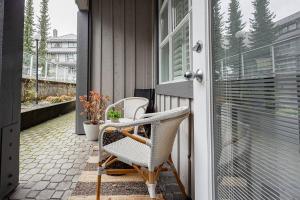 a porch with two chairs and a window at Designer Cozy Ski in and out in Whistler