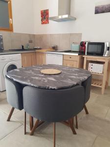 uma cozinha com uma mesa no meio em Le petit écureuil em Saint-Saturnin-dʼApt