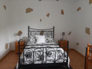 een slaapkamer met een zwart bed en een wit kussen bij Peaceful house set on a vineyard & work friendly in Valsequillo