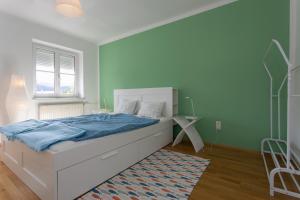 1 dormitorio con cama con sábanas azules y ventana en Familienglück in der Weststeiermark, en Sankt Oswald ob Eibiswald