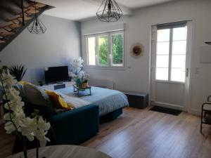 a living room with a bed and a couch at Les Terrasses du Pigeonnier, Duplex 4 pers en Baie de Somme in Vron