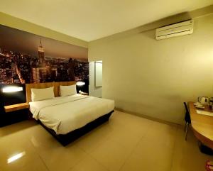 a hotel room with a bed and a view of a city at Hotel Sampurna Cirebon in Cirebon