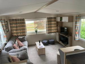 uma sala de estar com um sofá e uma televisão em Delightful Holiday Home at River Valley near Penzance em Penzance