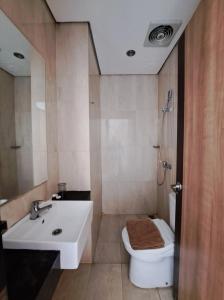 a bathroom with a white sink and a toilet at Hotel Sampurna Cirebon in Cirebon