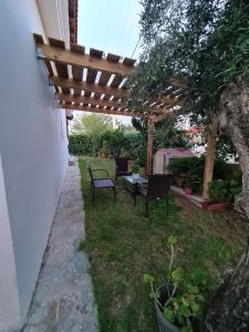 eine Terrasse mit Stühlen und einer hölzernen Pergola in der Unterkunft Semelia's Guest house in Spáta