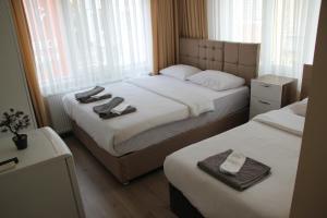 a hotel room with two beds with towels on them at Limon Pansiyon in Edirne