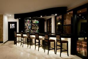 a bar with a row of chairs in a room at Villa Monticello Boutique Hotel in Accra