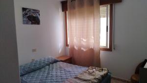 a small bedroom with a bed and a window at Vivienda 2 sin ascensor in Laxe