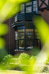 een gebouw met een raam met een hond op een balkon bij Vakantiewoning Guesthouse MOMO in Dilsen-Stokkem