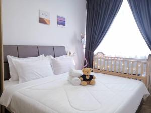 a teddy bear sitting on top of a bed at Hanns&KingBed&WIFI&Pool& Parking&Sauna&Sunshine Classic Comfort Homstay in Sibu