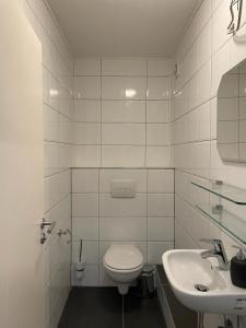FlyHigh Apartment Stuttgart VS2 في شتوتغارت: حمام ابيض مع مرحاض ومغسلة
