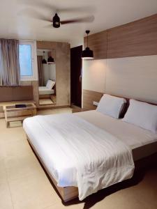 ein Schlafzimmer mit einem großen weißen Bett und einem Fenster in der Unterkunft Casa De Mount in Mount Ābu