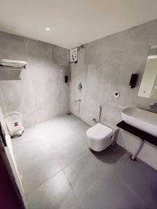 a bathroom with a white toilet and a sink at Casa De Mount in Mount Ābu +27 photos
