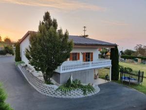 una casa blanca con un árbol y una entrada en Ferienhaus Panorama, en Rechnitz