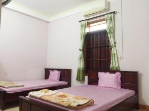 a room with two beds and a window at Nhà nghỉ Thủy Mười - Bắc Kạn City in Bak Kan