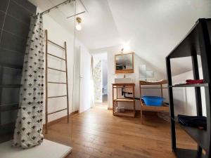 Habitación con escalera, escritorio y espejo. en Gîte Les Cerisiers, en Binic