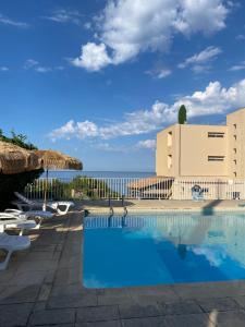 a swimming pool with a view of the ocean at HOTEL A RENA D'ORU in Coggia