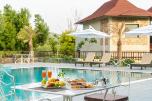 a table with food on it next to a pool at Sarasiruham Resort - Private Pool Villa in Udaipur in Udaipur