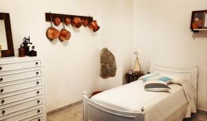 a bedroom with a white bed and a dresser at Tranquillità e comodità a due passi dal centro in Tortolì