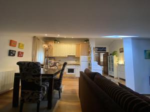 usgo beach apartment في Miengo: مطبخ وغرفة معيشة مع طاولة وأريكة