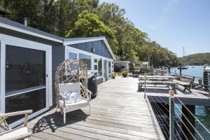 un molo con sedia e panche sull'acqua di Tides Reach Boathouse water-access-only a Church Point