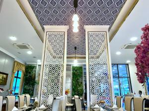 a dining room with tables and chairs and a ceiling at Banbua Grand Udon in Udon Thani
