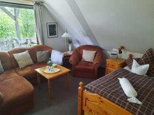een woonkamer met een bank, een bed en een tafel bij FeWo Min Egen in Neukirchen in Neukirchen