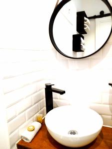 La salle de bains est pourvue d'un lavabo blanc et d'un miroir. dans l'établissement Havre de paix coeur de Vichy, à Vichy