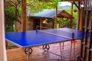 una mesa de ping pong en la cubierta de una casa en Chui Cottage with tennis facing Mt Kenya & near Ngare Ndare, en Timau