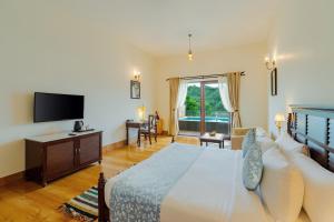 a bedroom with a bed and a flat screen tv at Sarasiruham Resort - Private Pool Villa in Udaipur in Udaipur