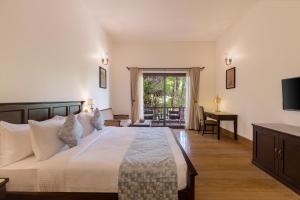 乌代浦Sarasiruham Resort - Private Pool Villa in Udaipur的一间卧室，配有一张床、一张书桌和一台电视