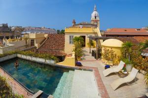 una piscina con sillas y un edificio en Casa Pombo Luxury 3 largeBR Duplex old city 300m2, en Cartagena de Indias