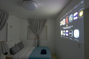 Habitación con cama y gran pantalla de ktop en 無料ビーチまで3分!BBQとホームシアターが楽しめるファミリー向け宿 Fujiyama Terrace en Yomitan