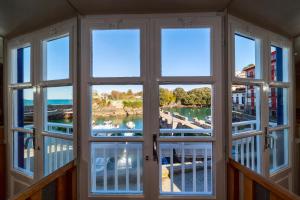 Habitación con ventana con vistas al puerto deportivo en Hotel&Spa El Puerto en Mundaka