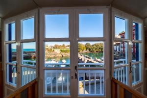 una camera con finestra affacciata su un porto turistico di Hotel&Spa El Puerto a Mundaka
