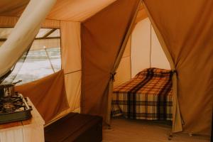 una habitación con una tienda de campaña con una cama en ella en CAMPING ONLYCAMP LES VAILHES, en Lodève
