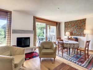 a living room with a fireplace and a table and chairs at Appartement Andrea in Verbier