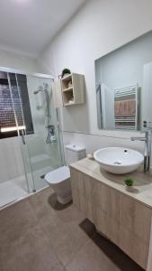 een badkamer met een wastafel, een toilet en een douche bij Casa da Penela in Nogueira de Ramuin