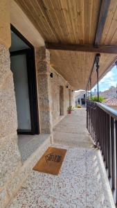 een stenen gebouw met een balkon met een deur bij Casa da Penela in Nogueira de Ramuin