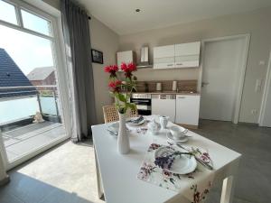 eine Küche mit einem weißen Tisch und einer Blumenvase darauf in der Unterkunft Studio - Apartment Steinmetz mit Balkon in Reken