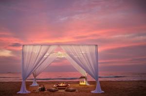 a wedding tent on the beach with a sunset at Cinnamon Bentota Beach - Signature Selection in Bentota