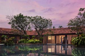 a villa with a pool in front of a house at Cinnamon Bentota Beach - Signature Selection in Bentota
